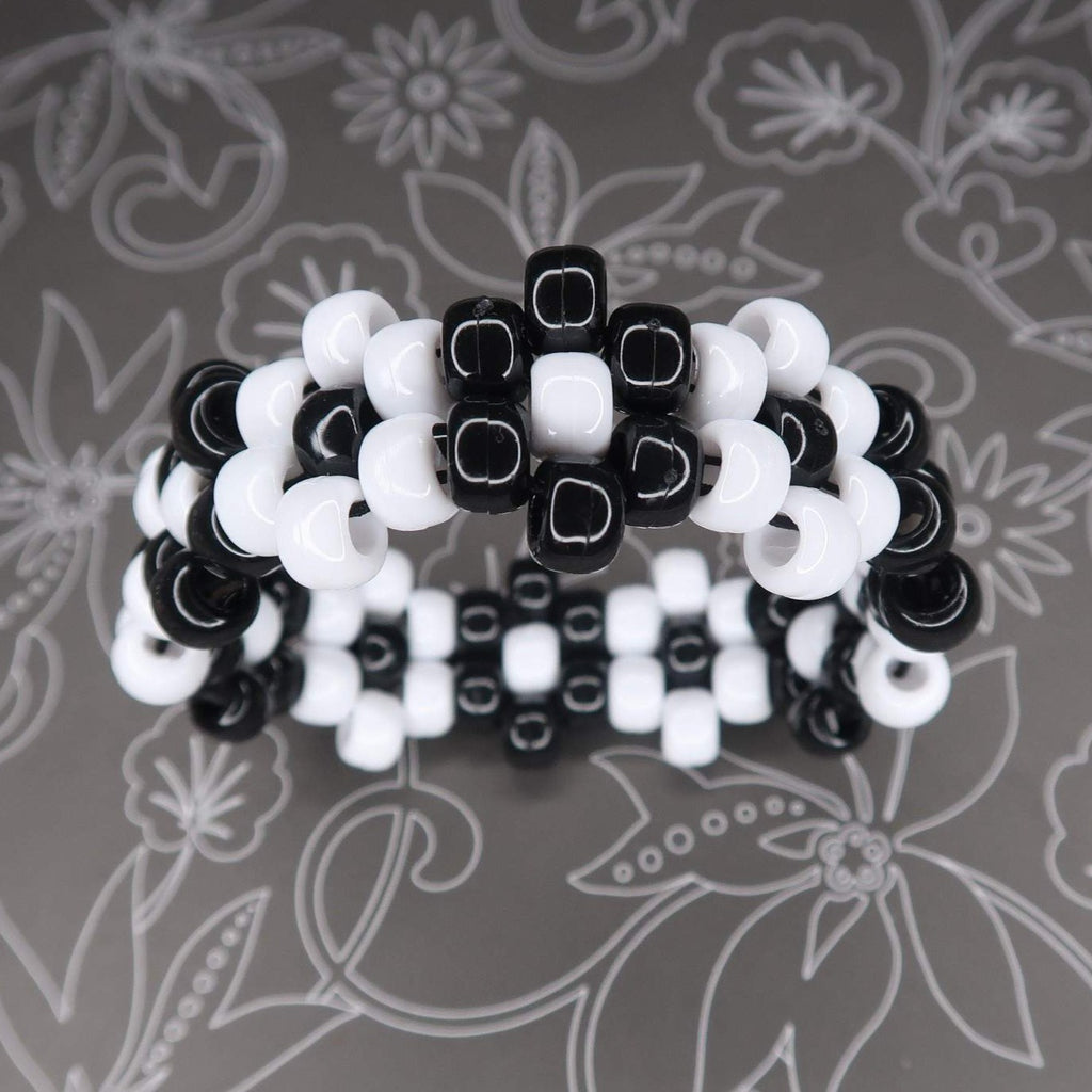 the flower bracelet alternates black and white flowers for a high-contrast neutral look that perfectly compliments any look, spooky, rave or everyday wear! made from shiny pony beads that are very sleek and soft to the touch